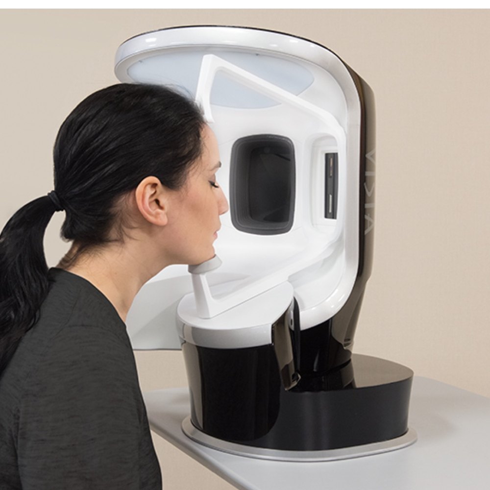 A patient receiving a VISIA skin analysis in the imaging booth at Florida Aesthetics and Wellness
